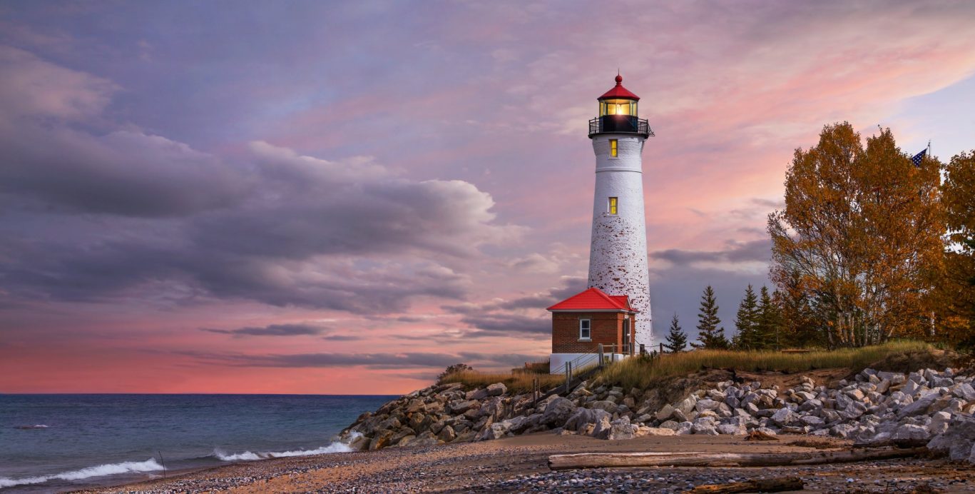 Dramatic sunset behind Point Iroquois Lighthouse on Lake Superior, Michigan.
