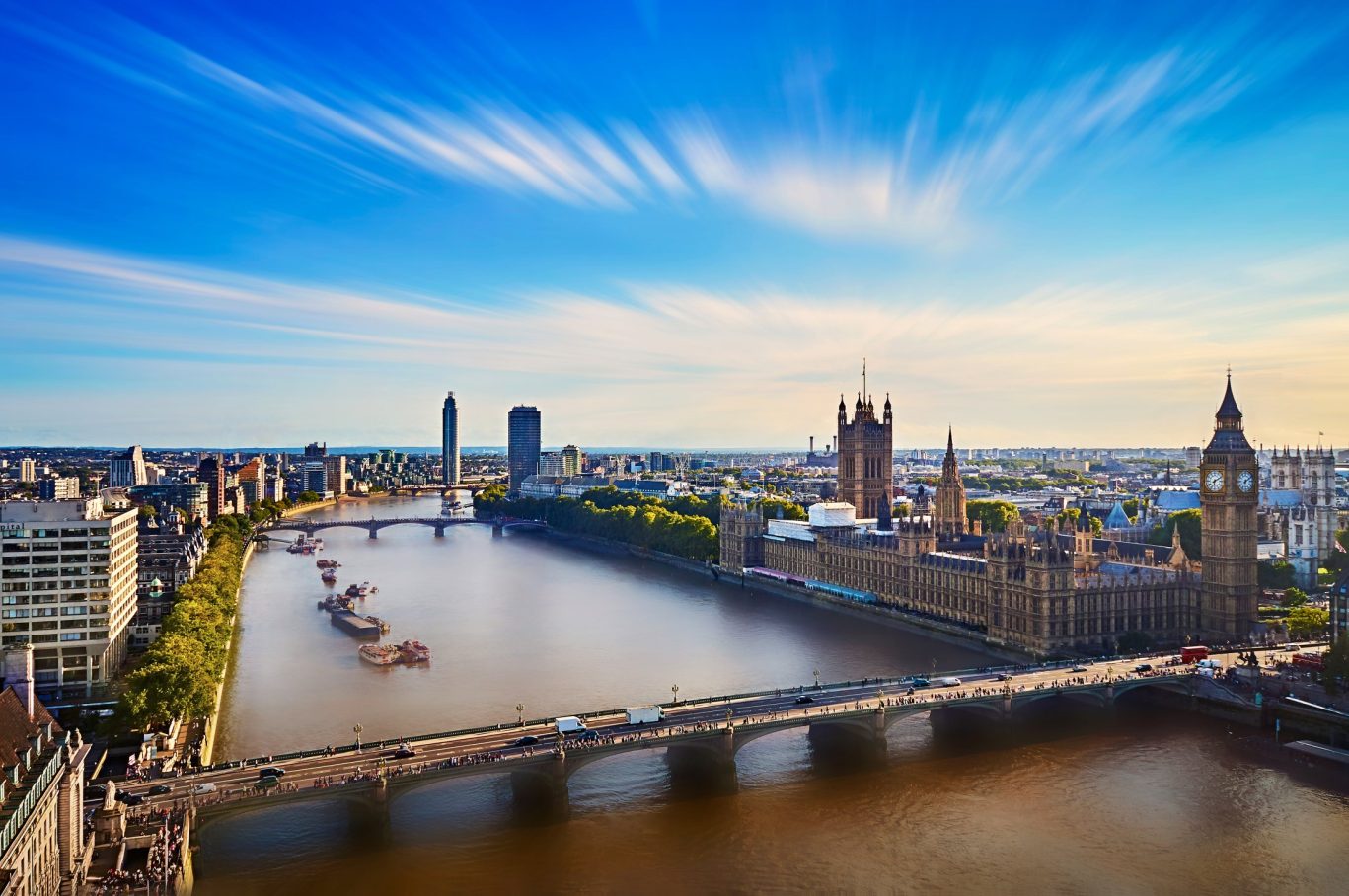 Scenic aerial view of Westminster Bridge, River Thames, and the Houses of Parliament in London at sunset.